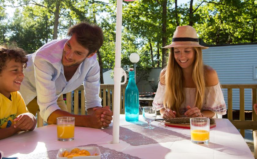 Famille sur la terrasse de leur mobil home Domaine de Soulac